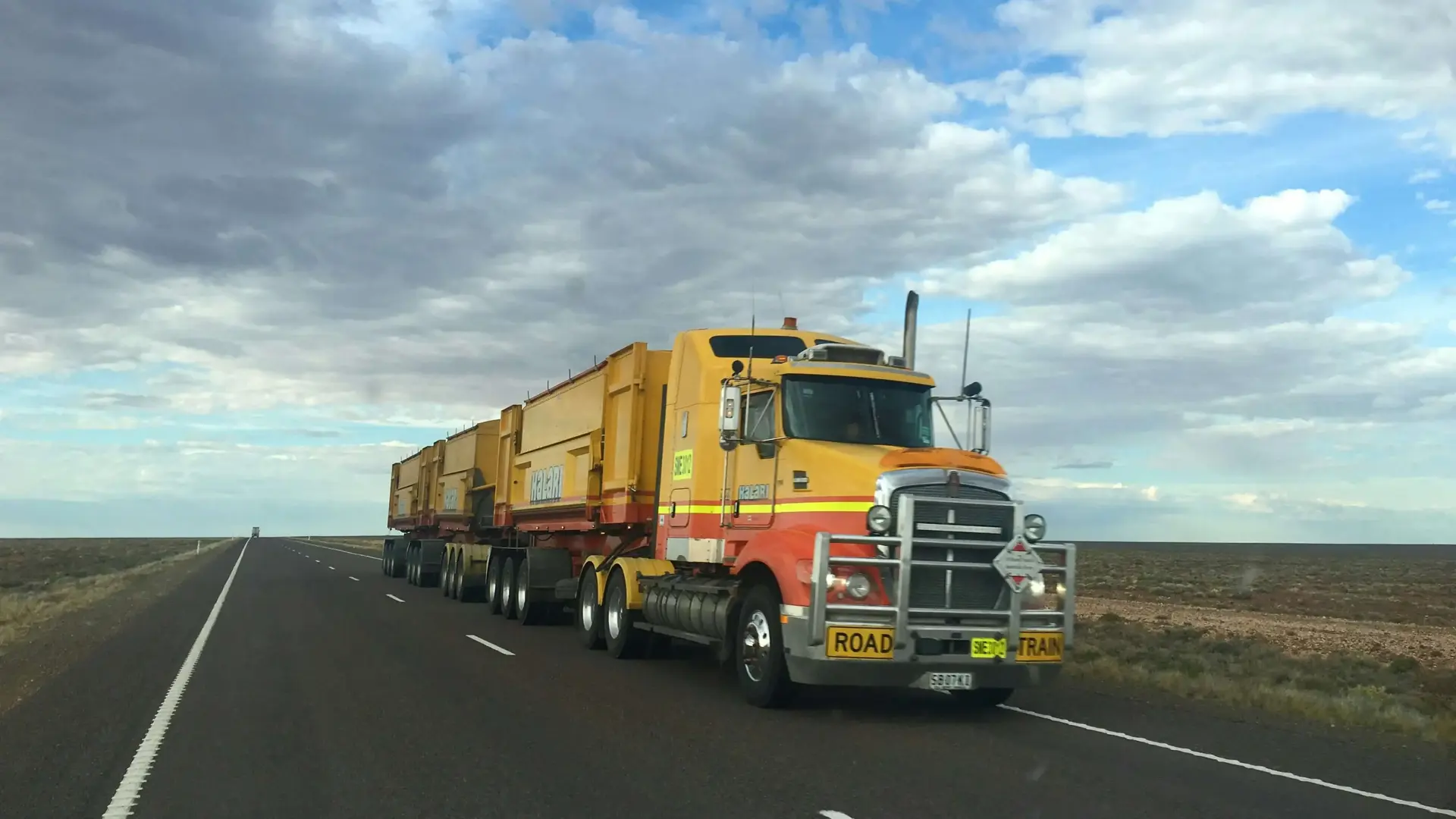 yellow road train on open highway